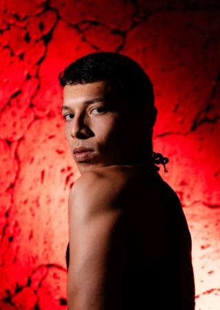 this picture shows dancer Erick in front of a red background