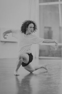 This picture shows a black-and-white photo of teacher Shira in the dance studio, dancing.